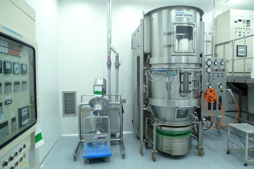 Stainless steel pharmaceutical manufacturing equipment in a sterile drug production facility.