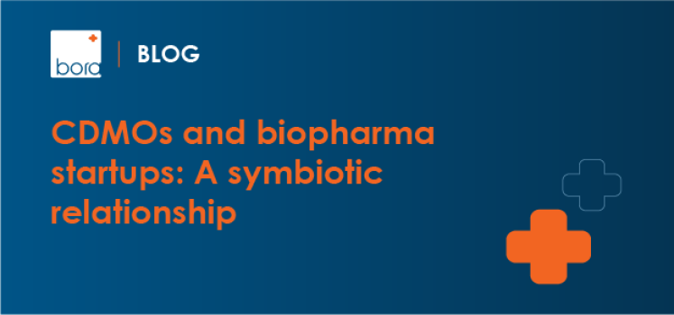 Blog banner: blue gradient background, orange headline 'CDMOs and biopharma startups: A symbiotic relationship' with an orange plus icon on the right.
